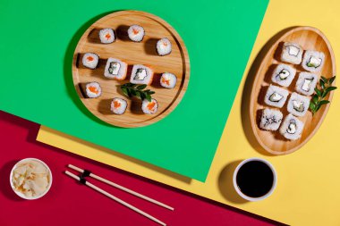 Sushi on a plate on a bright, colored background.