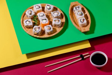 Sushi on a plate on a bright, colored background.