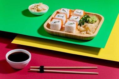 Parlak, renkli arka planda bir tabakta suşi..