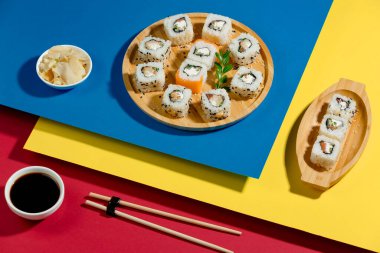 Parlak, renkli arka planda bir tabakta suşi..