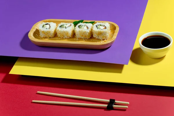 色彩艳丽的背景上的盘子上的寿司 — 图库照片