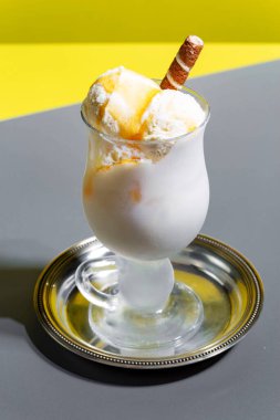 Dondurma masanın üstünde, parlak renkli bir arka planda.