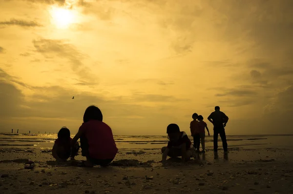 Grupo silhueta de crianças brincando na praia — Fotografia de Stock