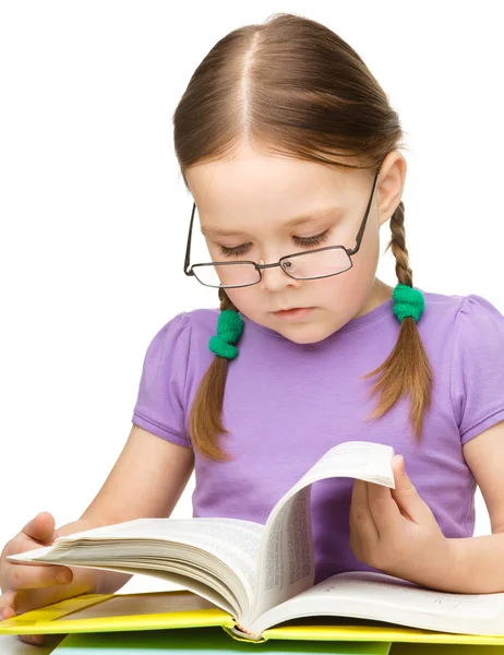 Bonito menina leitura livro usando óculos — Fotografia de Stock