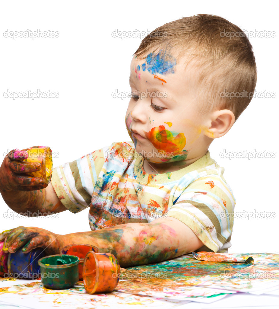 Little boy is playing with paints