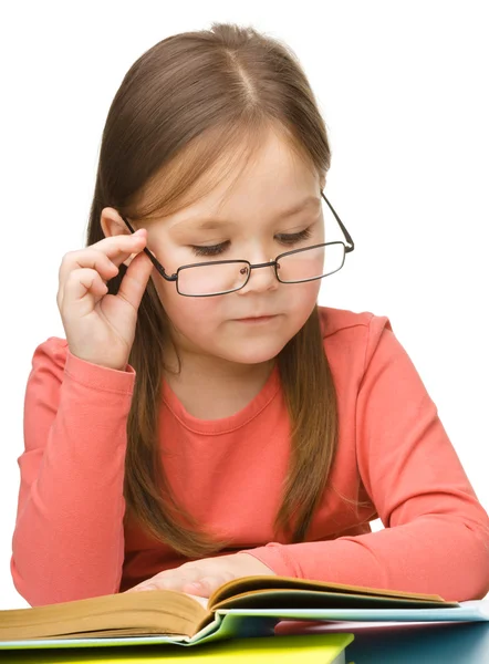 Schattig klein meisje het lezen van boek dragen van een bril — Stockfoto