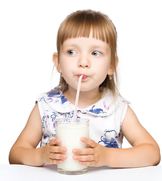 Cute little girl drinks milk using drinking straw — Stock Photo, Image