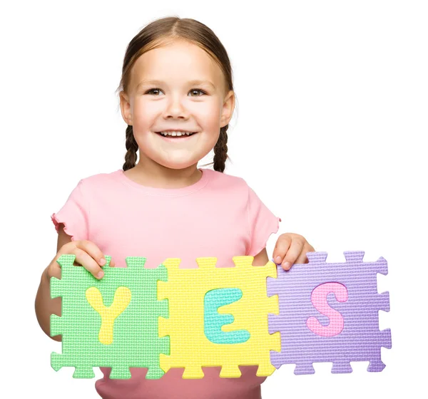 Cute little girl is holding Yes slogan — Stock Photo, Image