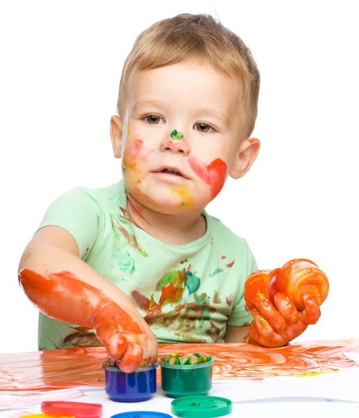 Niño está agarrando un poco de pintura con los dedos —  Fotos de Stock