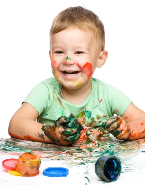 Kind is grijpen sommige verf met behulp van vingers — Stockfoto