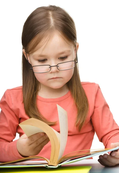 Bonito menina leitura livro usando óculos — Fotografia de Stock