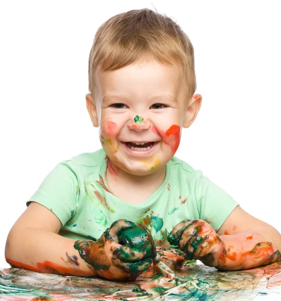 Kind is grijpen sommige verf met behulp van vingers — Stockfoto