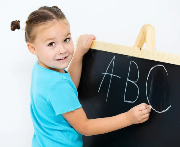 Kleines Mädchen zeigt Buchstabe e auf dem Alphabet — Stockfoto