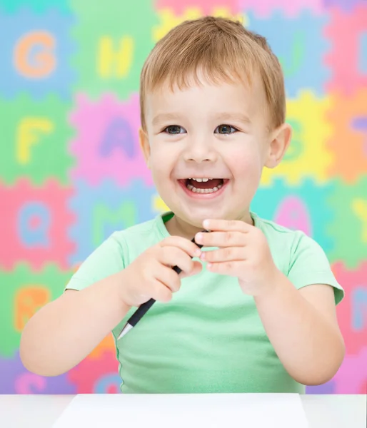 Little girl is writing using a pen — Stock Photo, Image