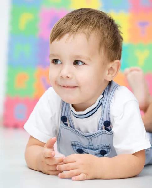 Liten pojke är att lägga på ett golv — Stockfoto