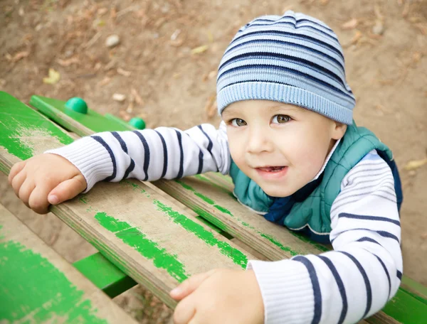 Kleine jongen speelt op speelplaats — Stockfoto