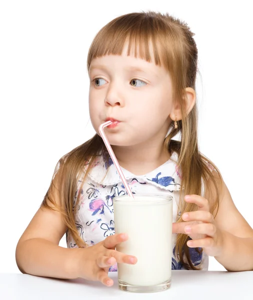 Cute little girl drinks milk using drinking straw — Stock Photo, Image