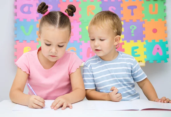 Kinder schreiben an ihren Büchern — Stockfoto