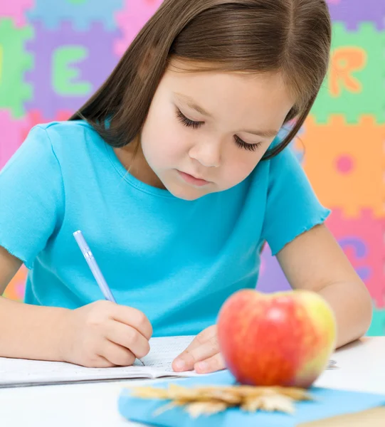 小さな女の子は、ペンを使用して書いています。 — ストック写真