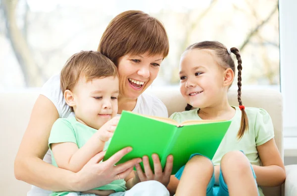 Матері читання книги для своїх дітей — стокове фото