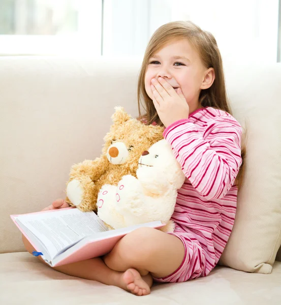 La bambina sta leggendo un libro per i suoi orsacchiotti. — Foto Stock