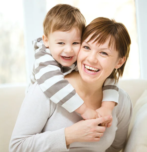 Feliz hijo piggybacking su madre — Foto de Stock