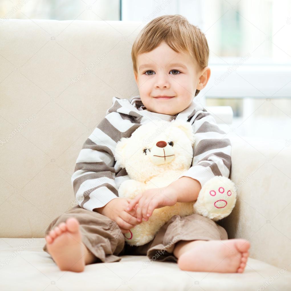 Little boy is holding his teddy bear