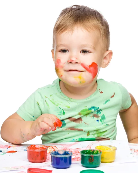 Menino está brincando com tintas — Fotografia de Stock