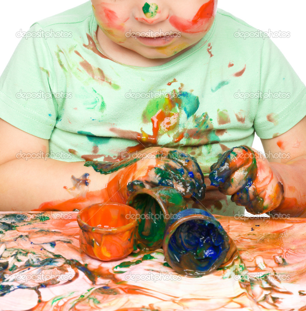 Little boy is playing with paints