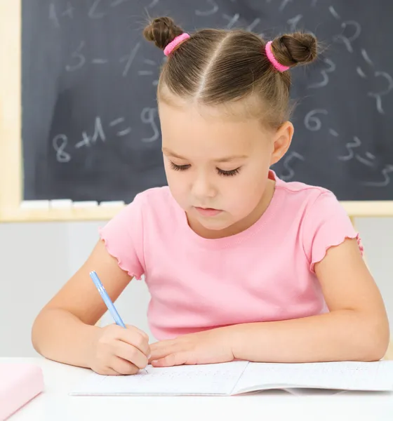 La niña está escribiendo usando un bolígrafo —  Fotos de Stock