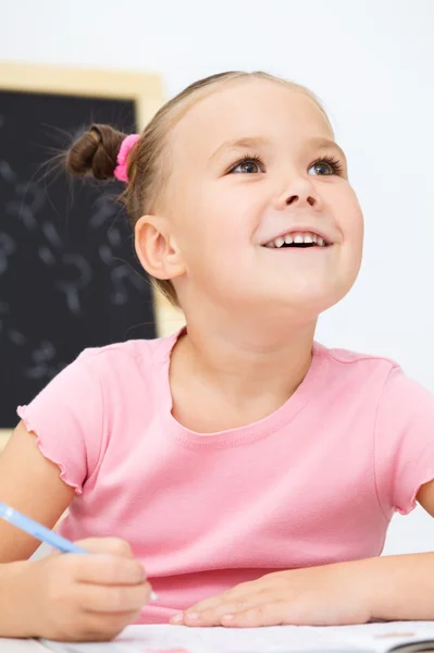 La bambina sta scrivendo usando una penna — Foto Stock