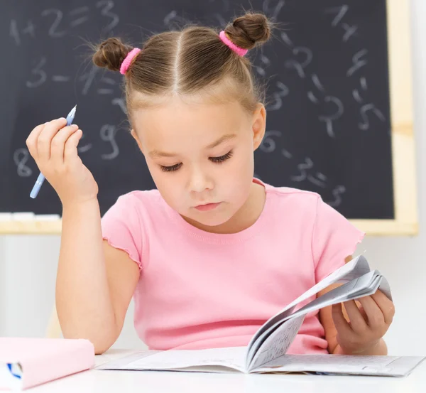 Kleines Mädchen studiert — Stockfoto