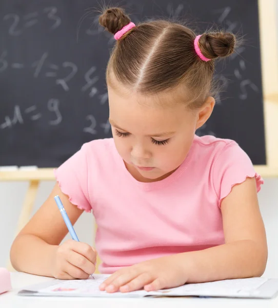 La niña está escribiendo usando un bolígrafo — Foto de Stock