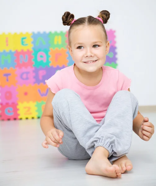 Little girl is sitting on floor in preschool — Stock Photo, Image