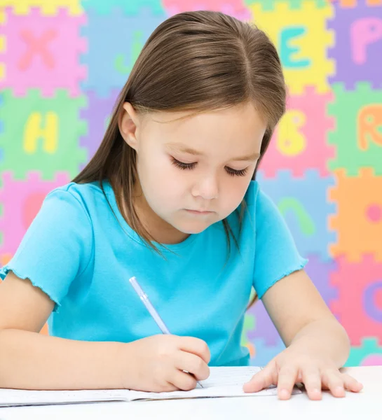 La niña está escribiendo usando un bolígrafo —  Fotos de Stock