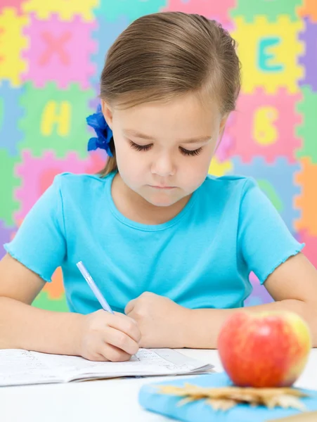 La bambina sta scrivendo usando una penna — Foto Stock