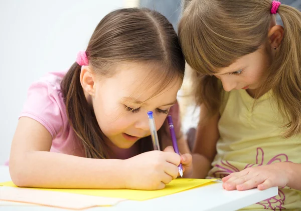 Little girl is writing using a pen — Stock Photo, Image