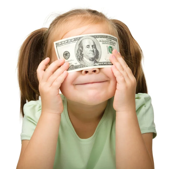 Маленькая девочка закрывает глаза долларами — стоковое фото