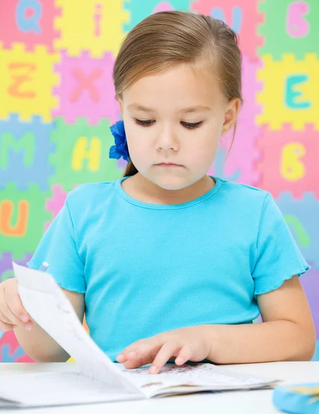 La niña está escribiendo usando un bolígrafo — Foto de Stock