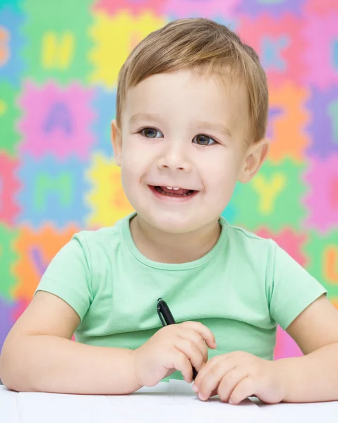 Little boy is writing on his copybook — Stock Photo, Image