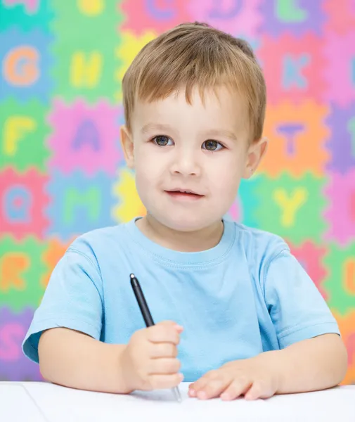 Küçük çocuk onun defterini yazıyor — Stok fotoğraf