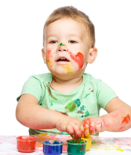 Menino está brincando com tintas — Fotografia de Stock