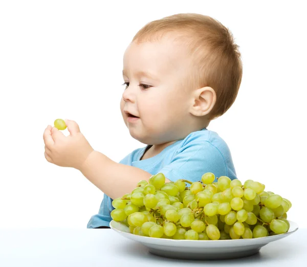 Menino está comendo uvas — Fotografia de Stock