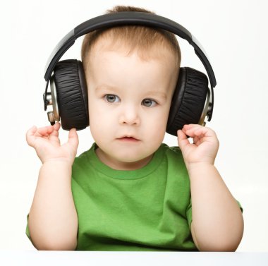 sevimli küçük çocuk kulaklık kullanarak müzik keyfi