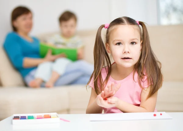 Kleines Mädchen spielt mit Knetmasse — Stockfoto