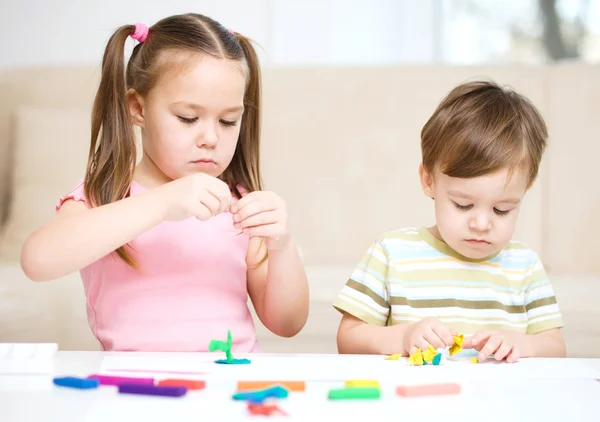 Sister and brother are playing with plasticine — Stock Photo, Image