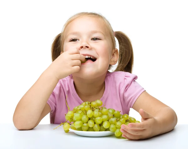 La bambina sta mangiando uva. — Foto Stock