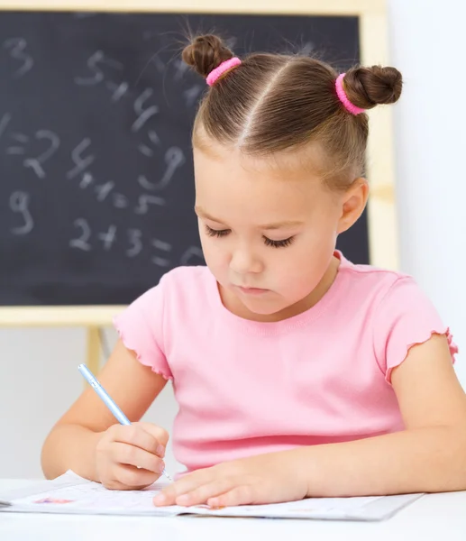 La niña está escribiendo usando un bolígrafo —  Fotos de Stock