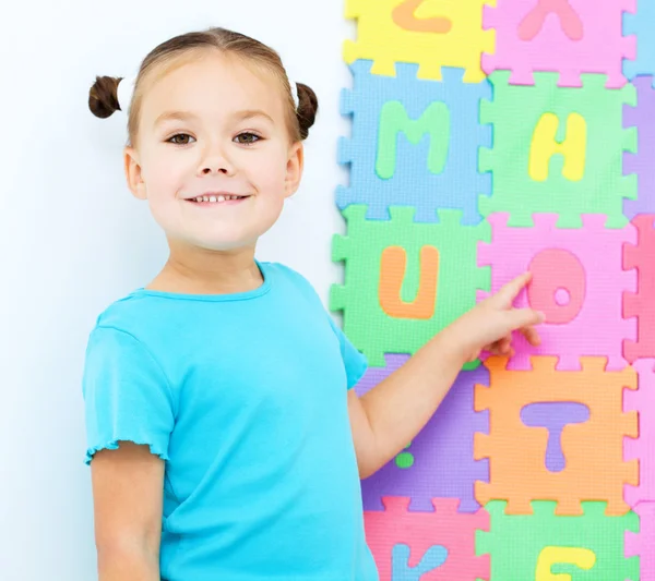 Petite fille pointe la lettre O sur l'alphabet — Photo