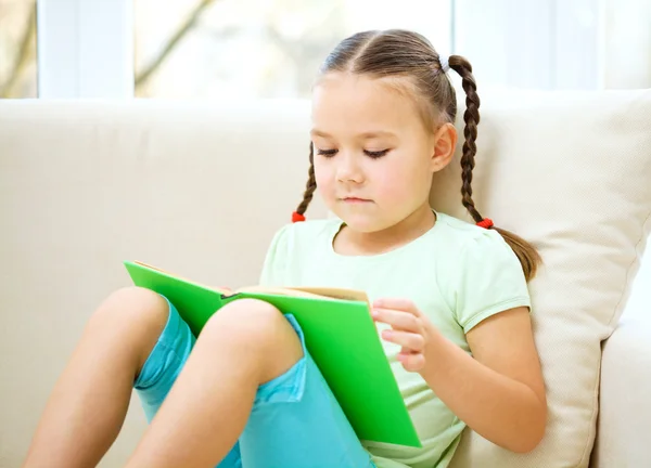 Klein meisje leest een boek — Stockfoto